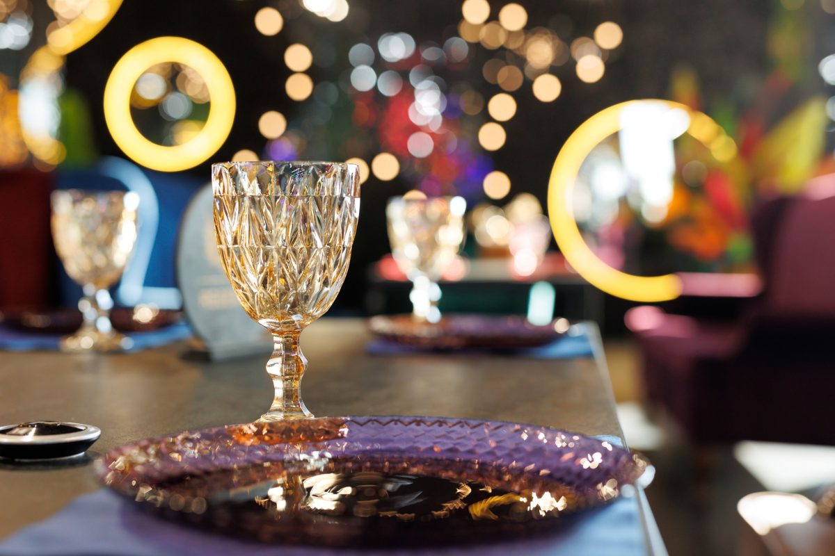 opulent glassware on a party table with twinkling lights