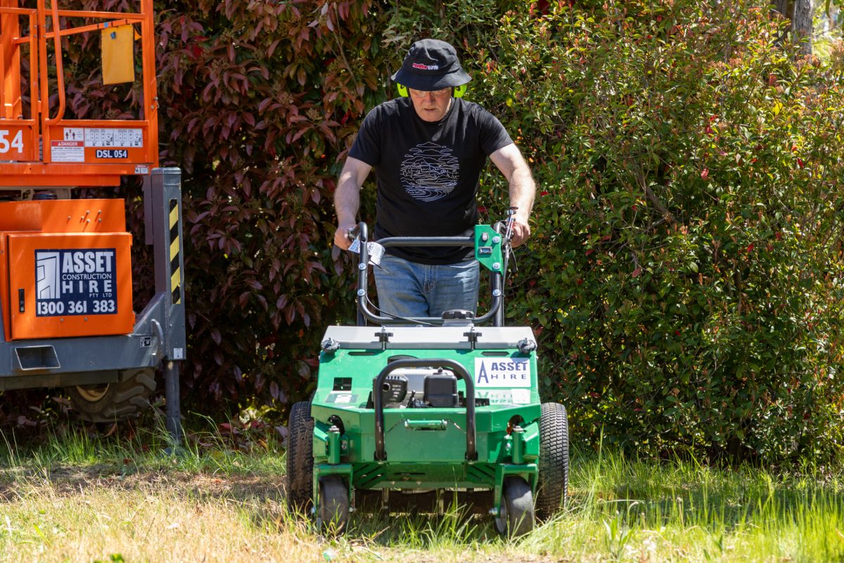 man using aerator lawn coring machine