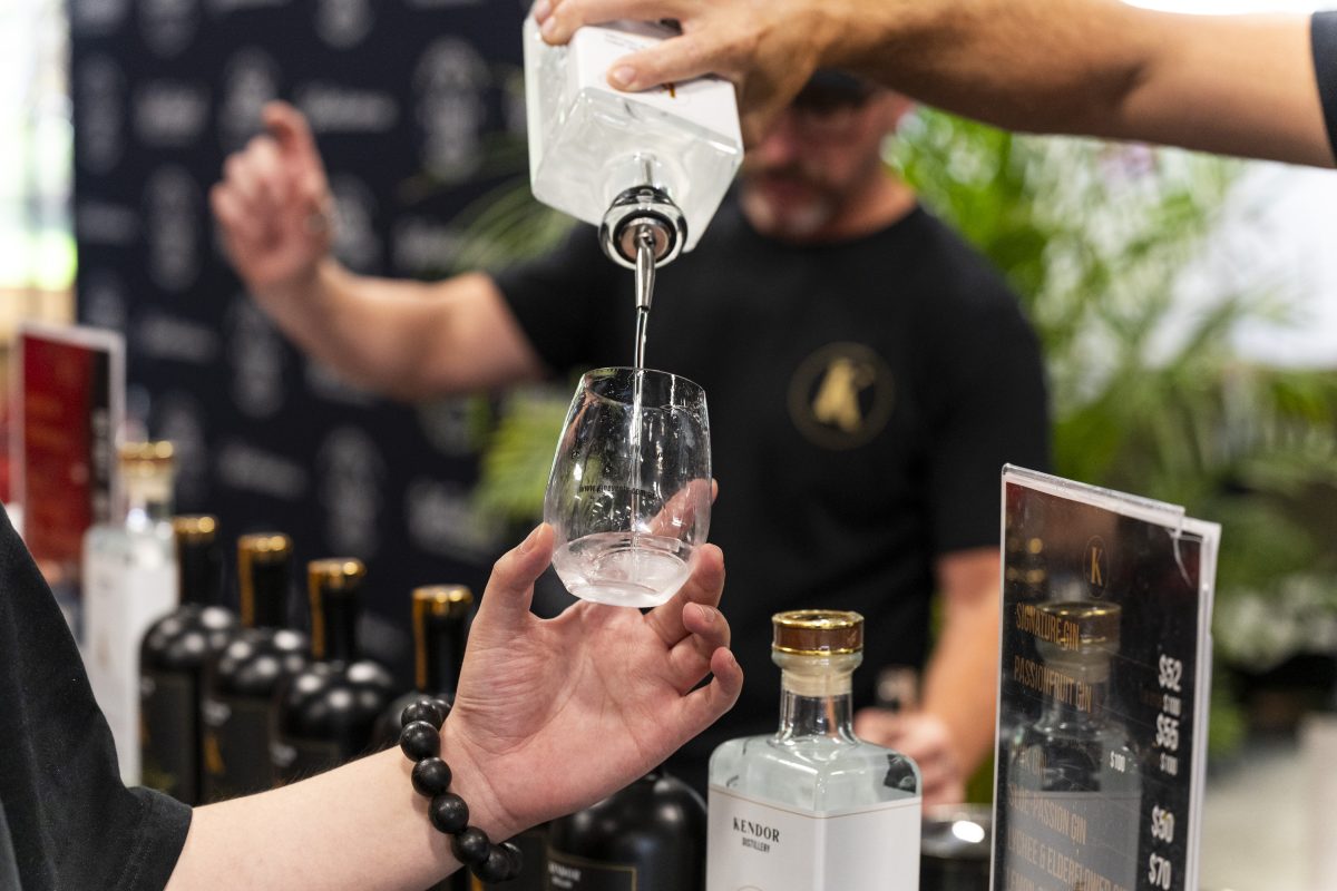 A hand pours gin into a glass. 