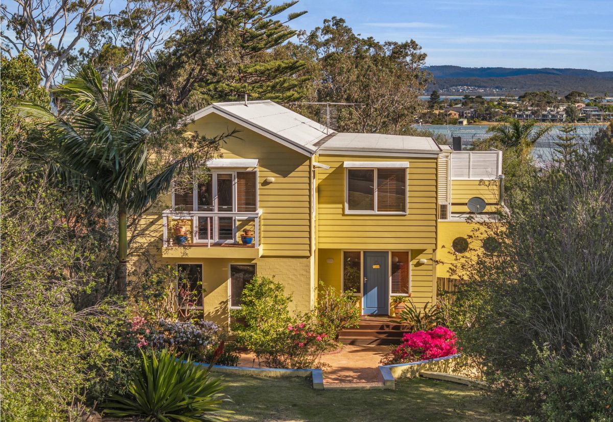 pastel yellow house with circular garden and juliette balcony