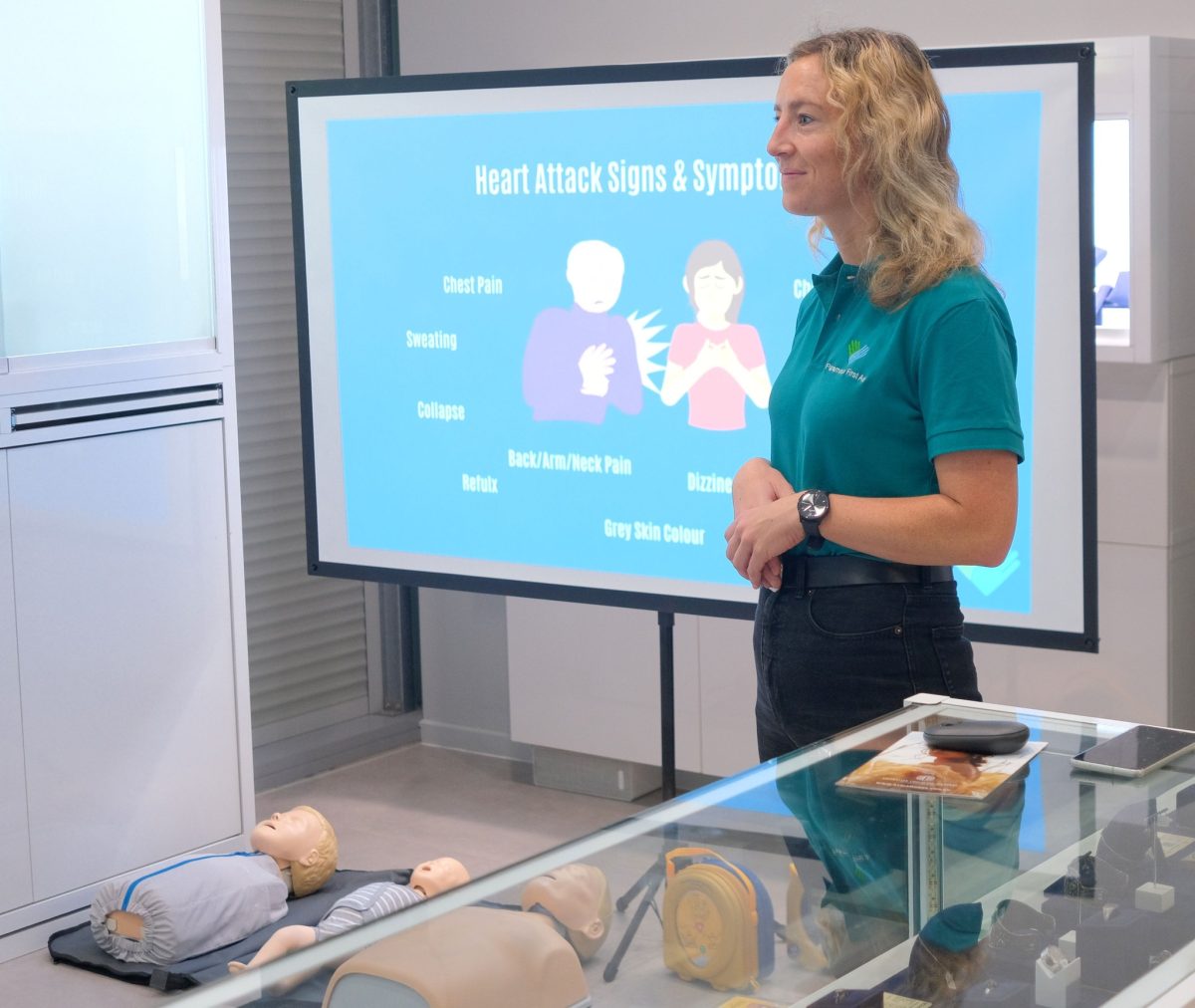 First aid provider standing in front of a projector screen
