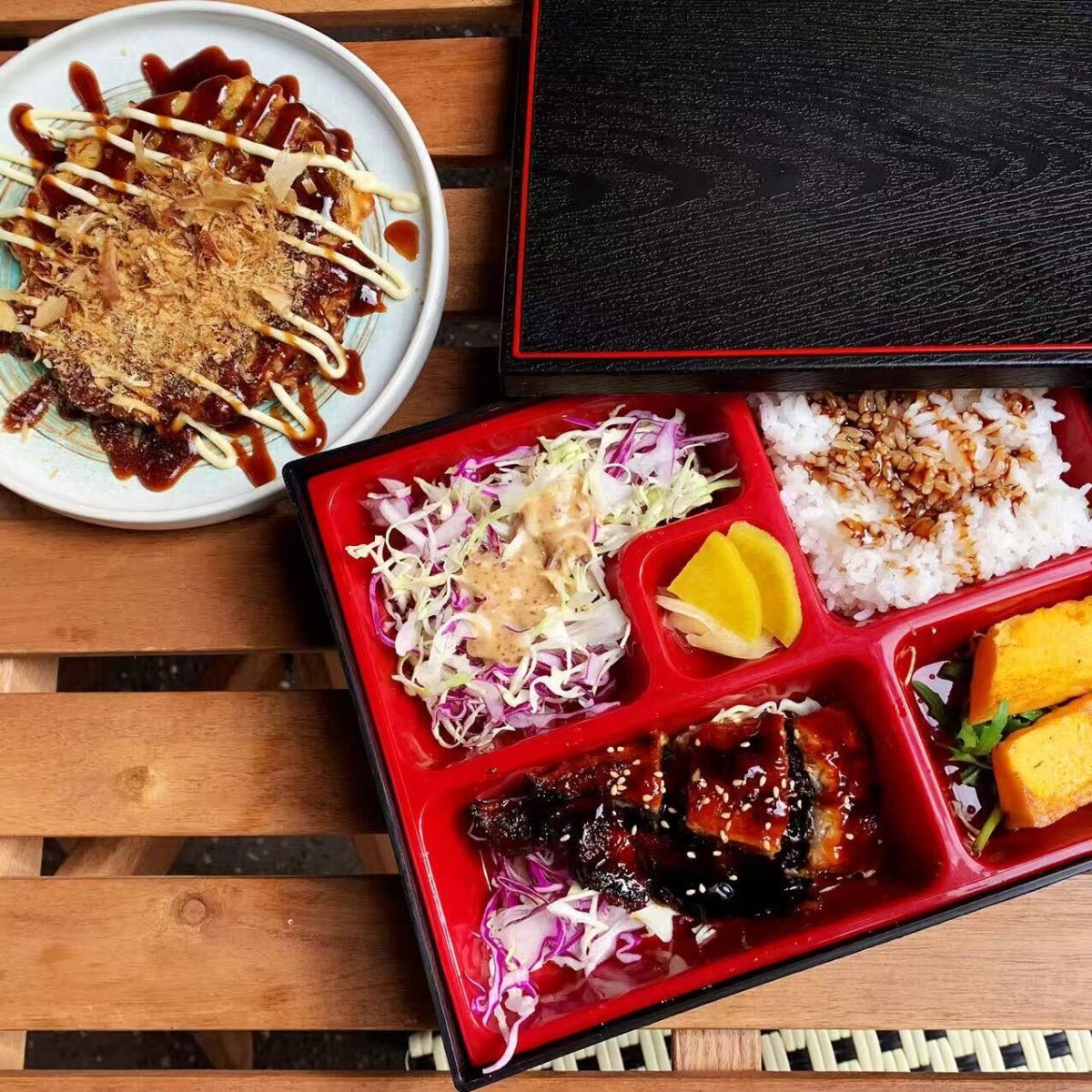 A bento box and dish drizzled with sauces.