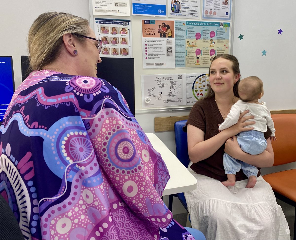 mother holding baby in postnatal healthcare consulting room