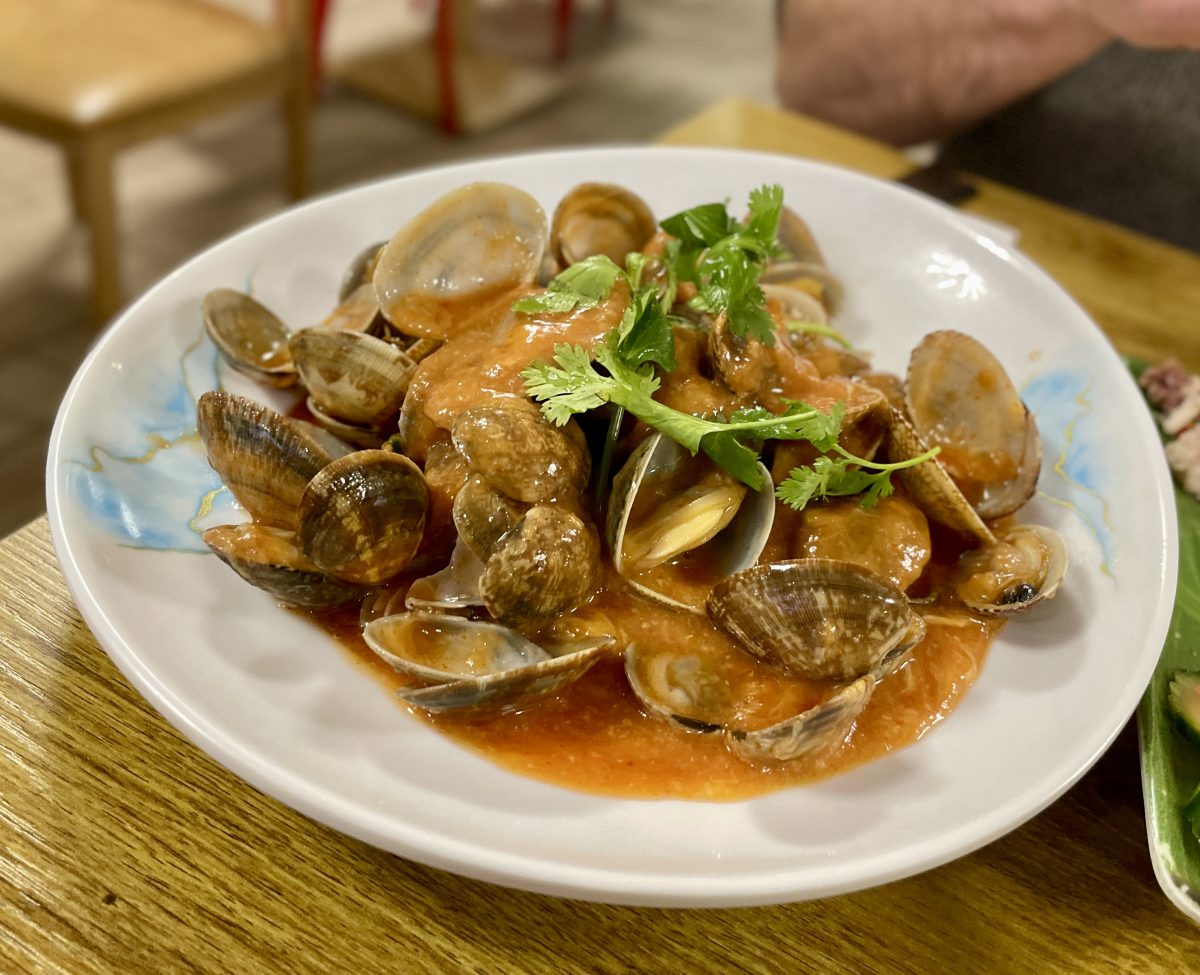 A bowl of pippies in a red sauce.