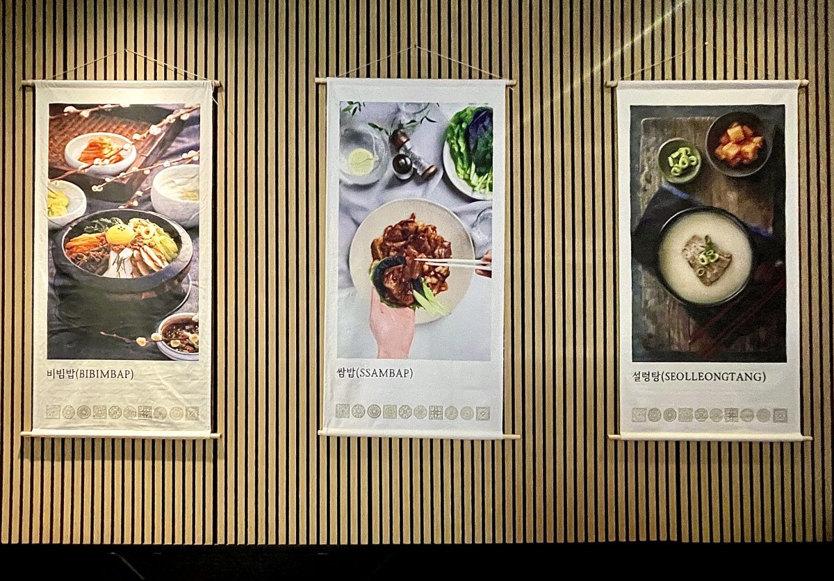 Three large wall hangings displaying different Korean dishes.