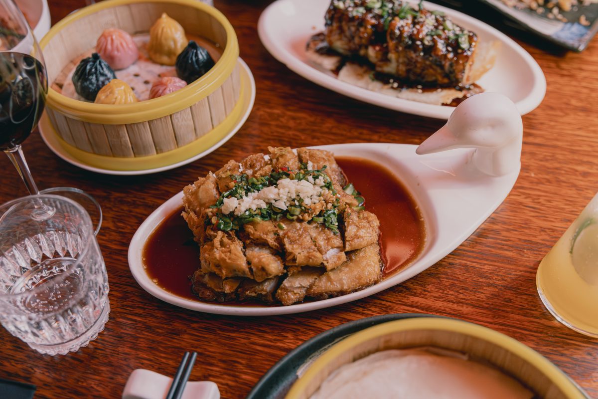 A plate of crispy looking fried duck sitting in a sauce.