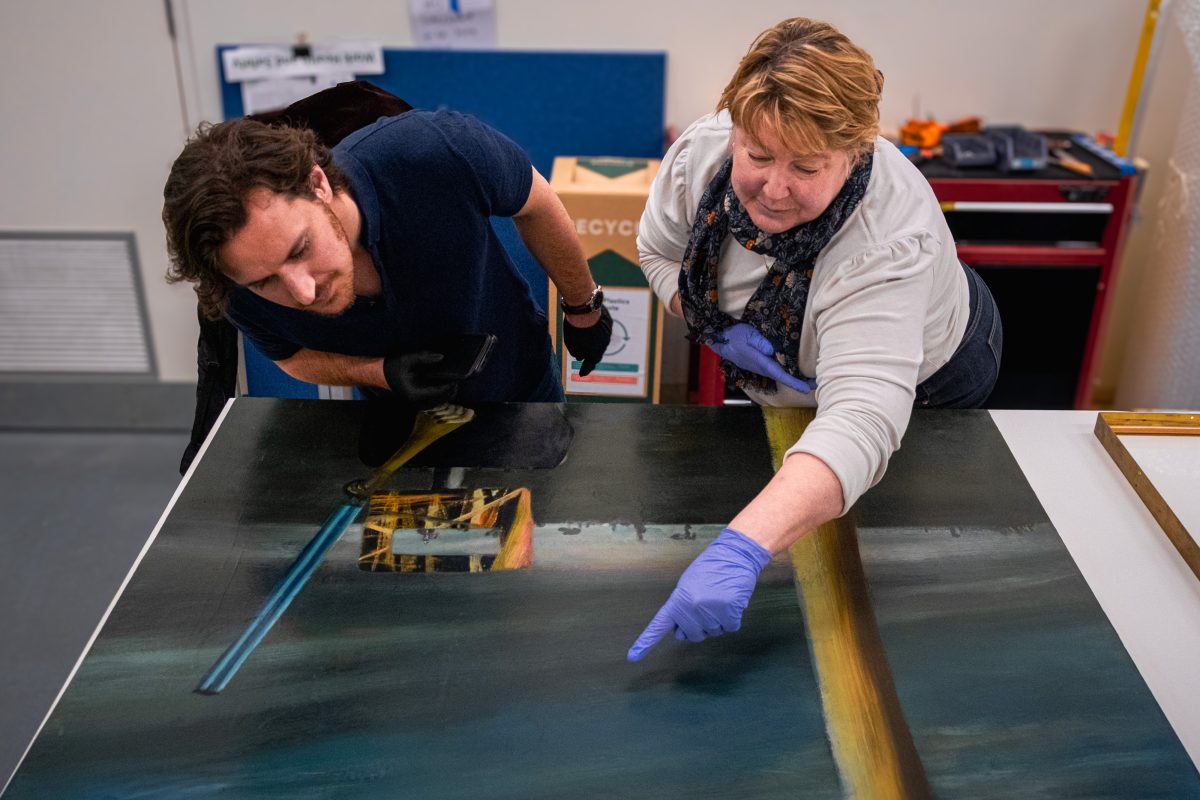 two people examining at a painting