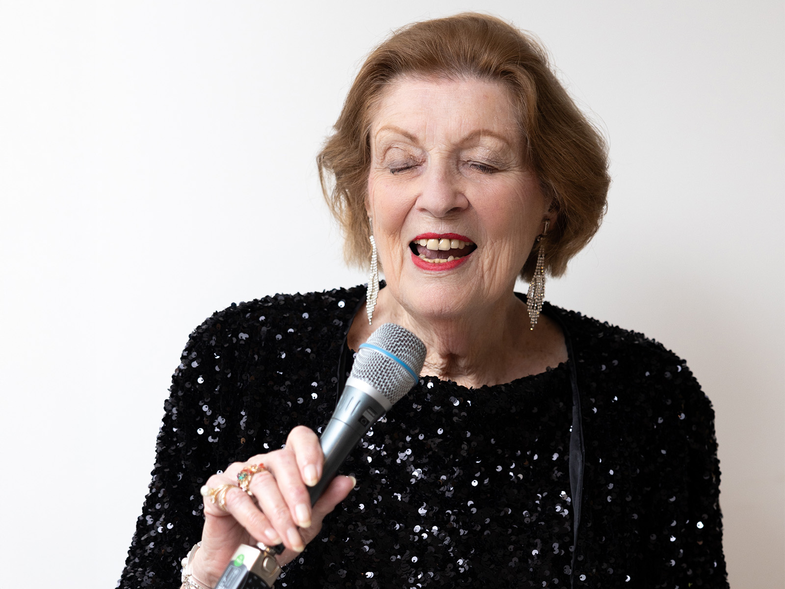 Sandie White singing into a microphone