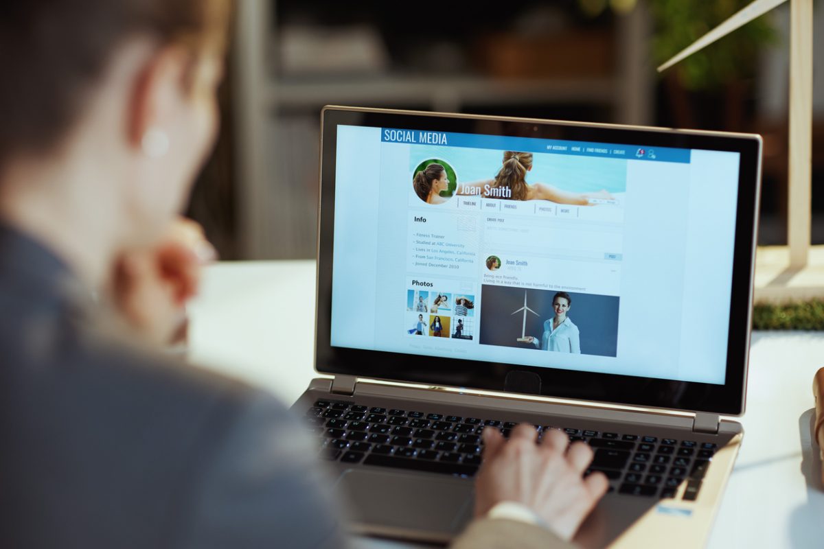 Seen from behind a person reads news on social media