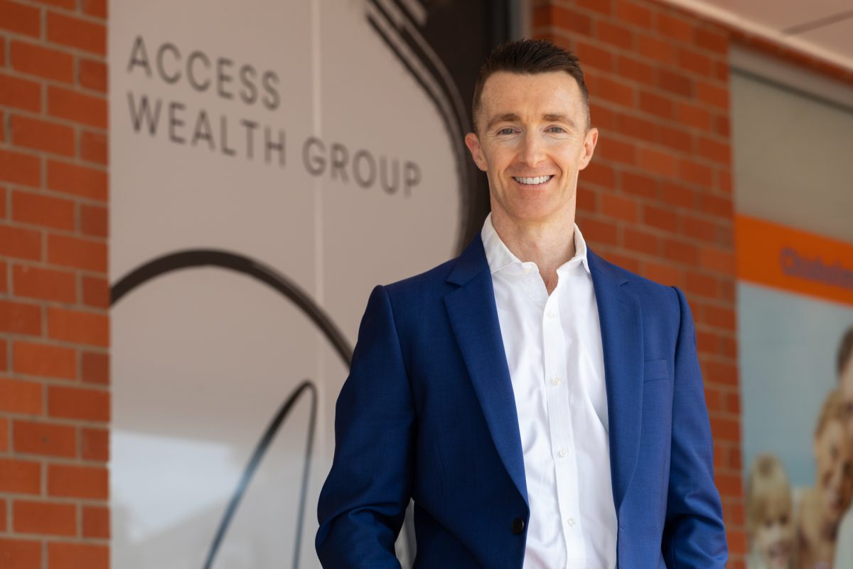 Brendan Doherty standing in front of Access Wealth Group signage