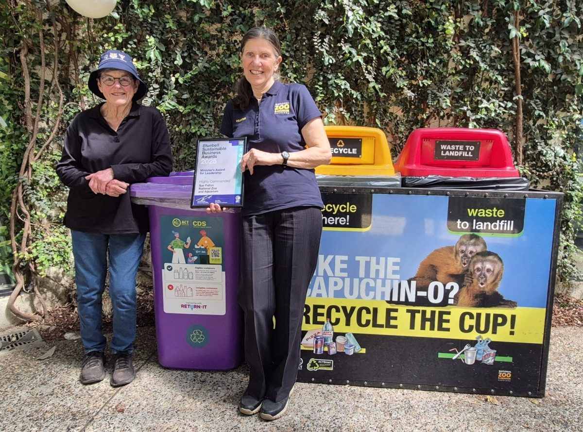 Sue Fallon with fellow volunteer Ann in front of recycling bins