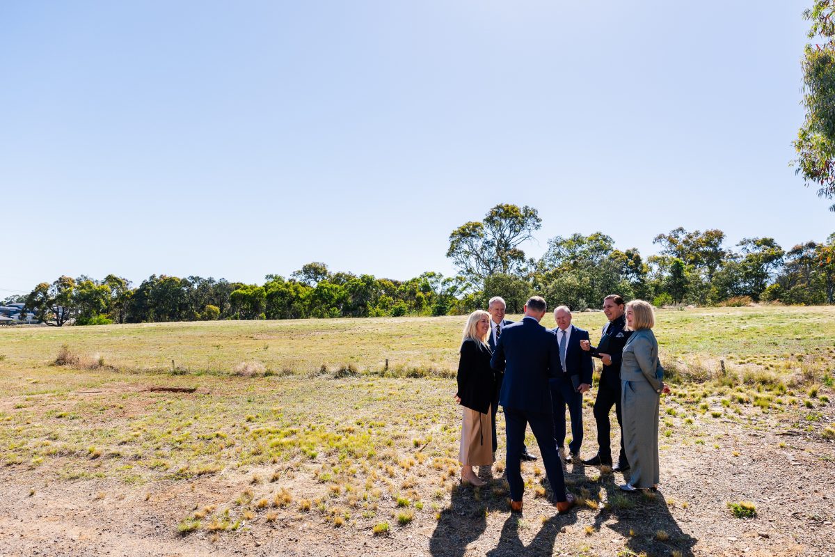 people standing next to an empty block of land