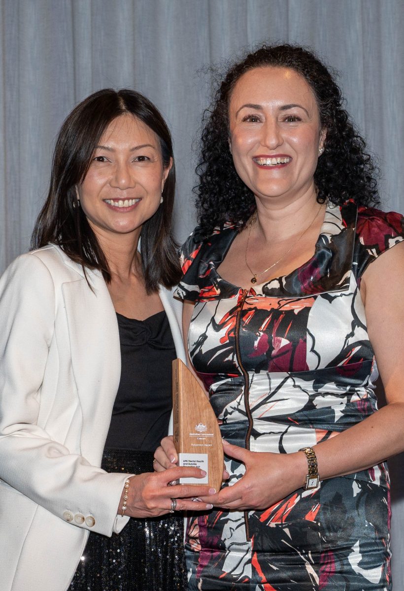 two smiling women with an award