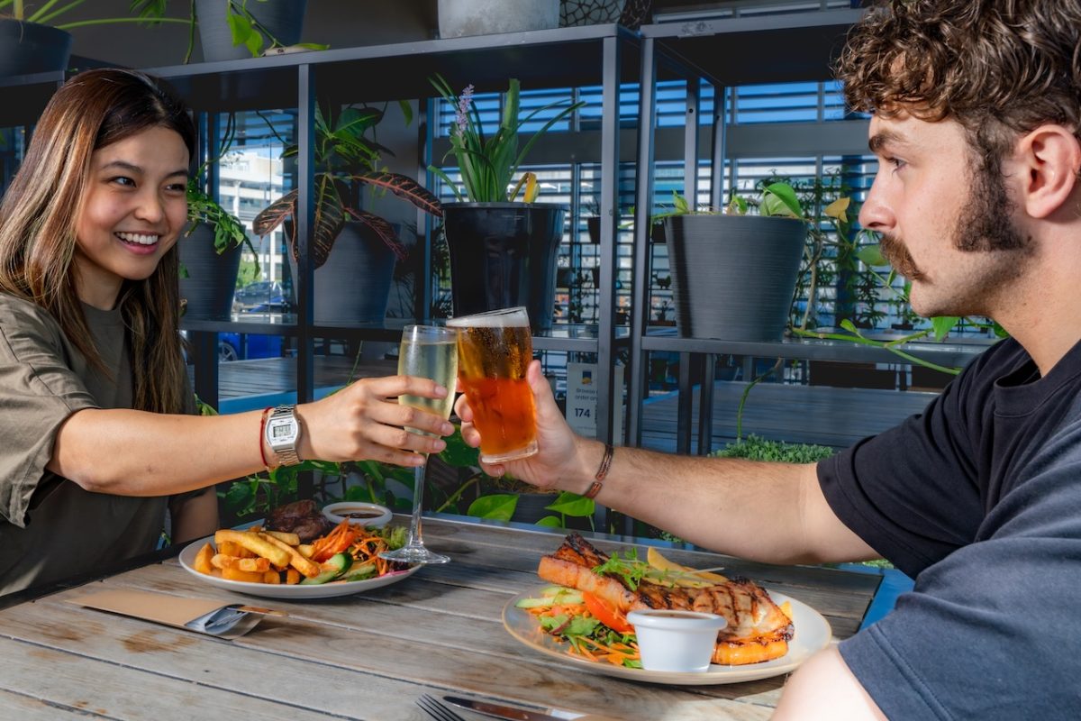 Two people cheersing at a table.