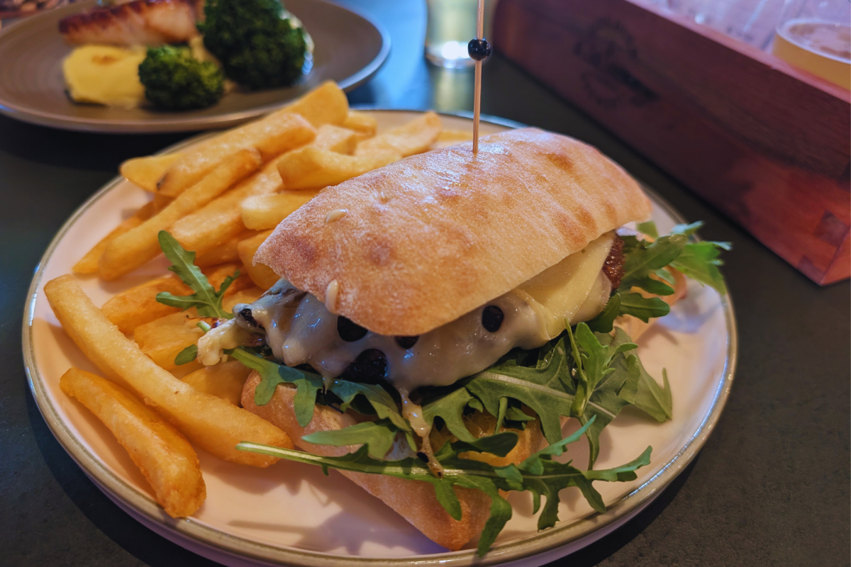 A steak sandwich with a side of chips.