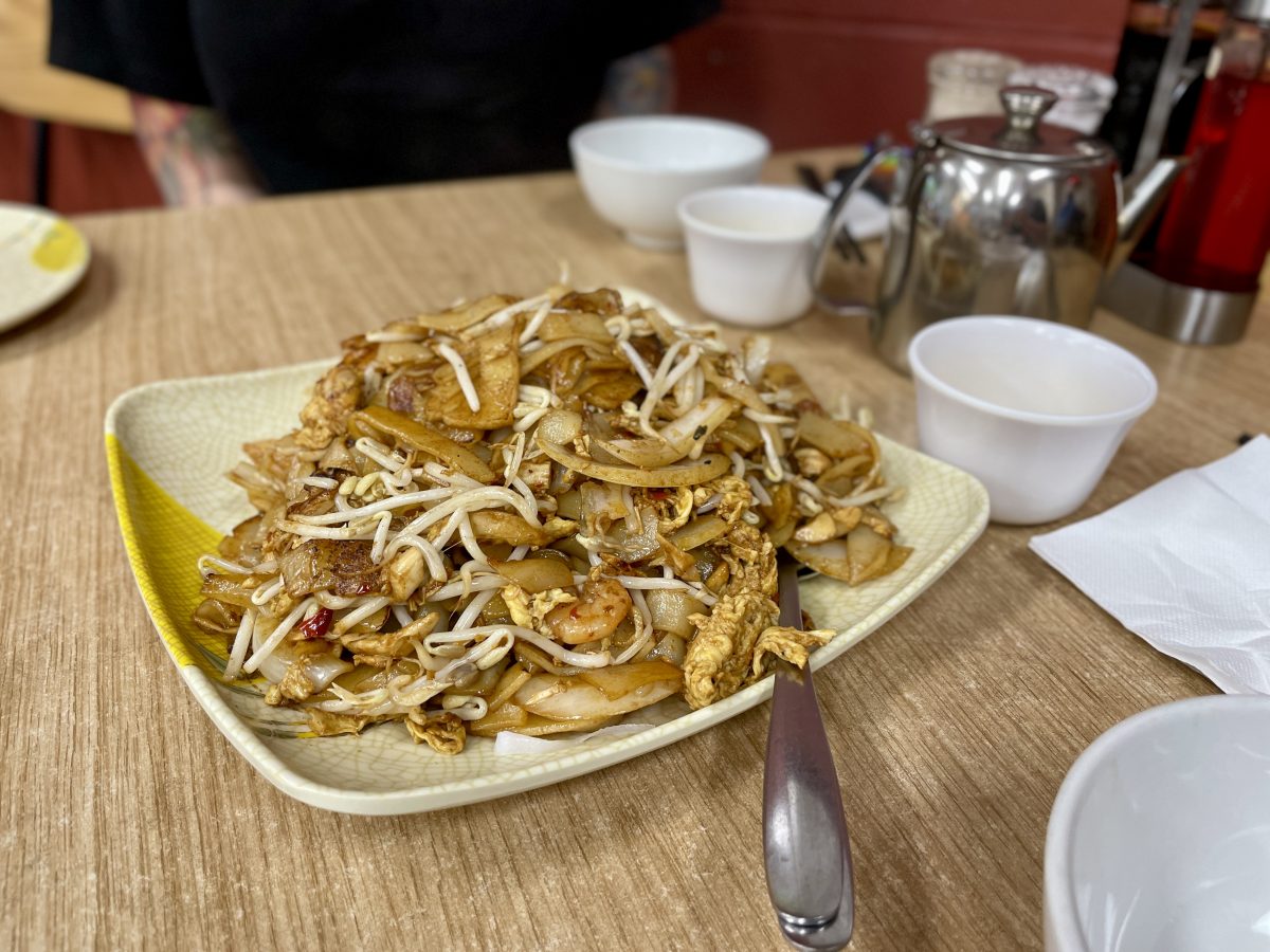A plate of thick noodles with bean sprouts.