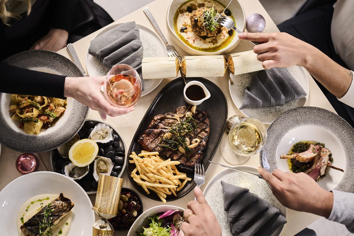 birds-eye view of a table of food with three people sitting around it