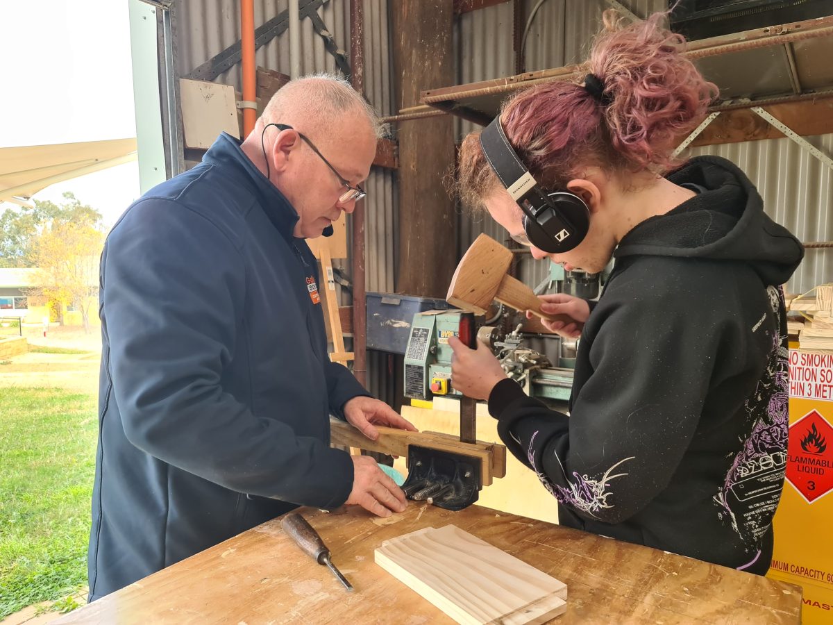 Two people building in a woodworks class.