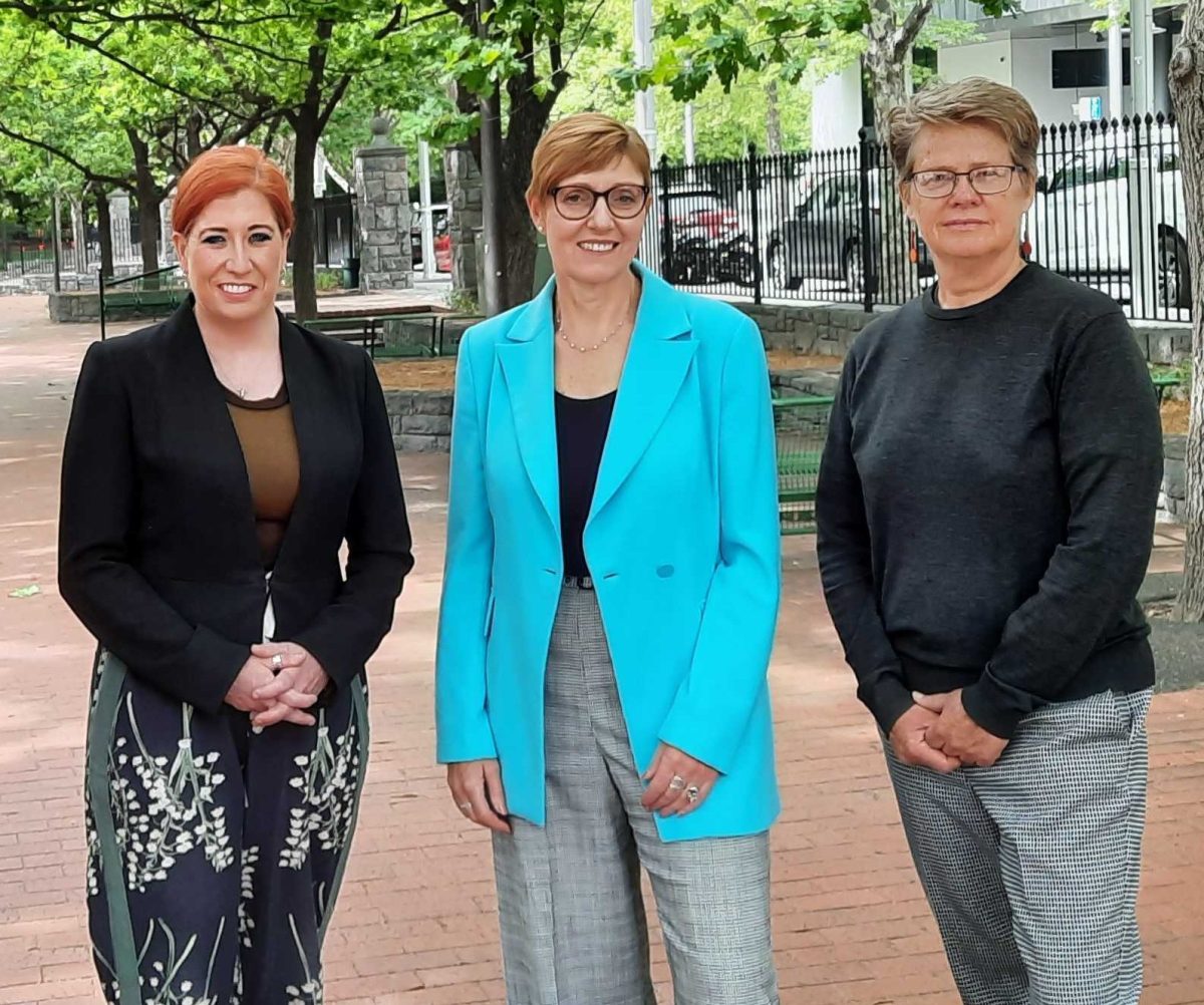 three women standing in a park
