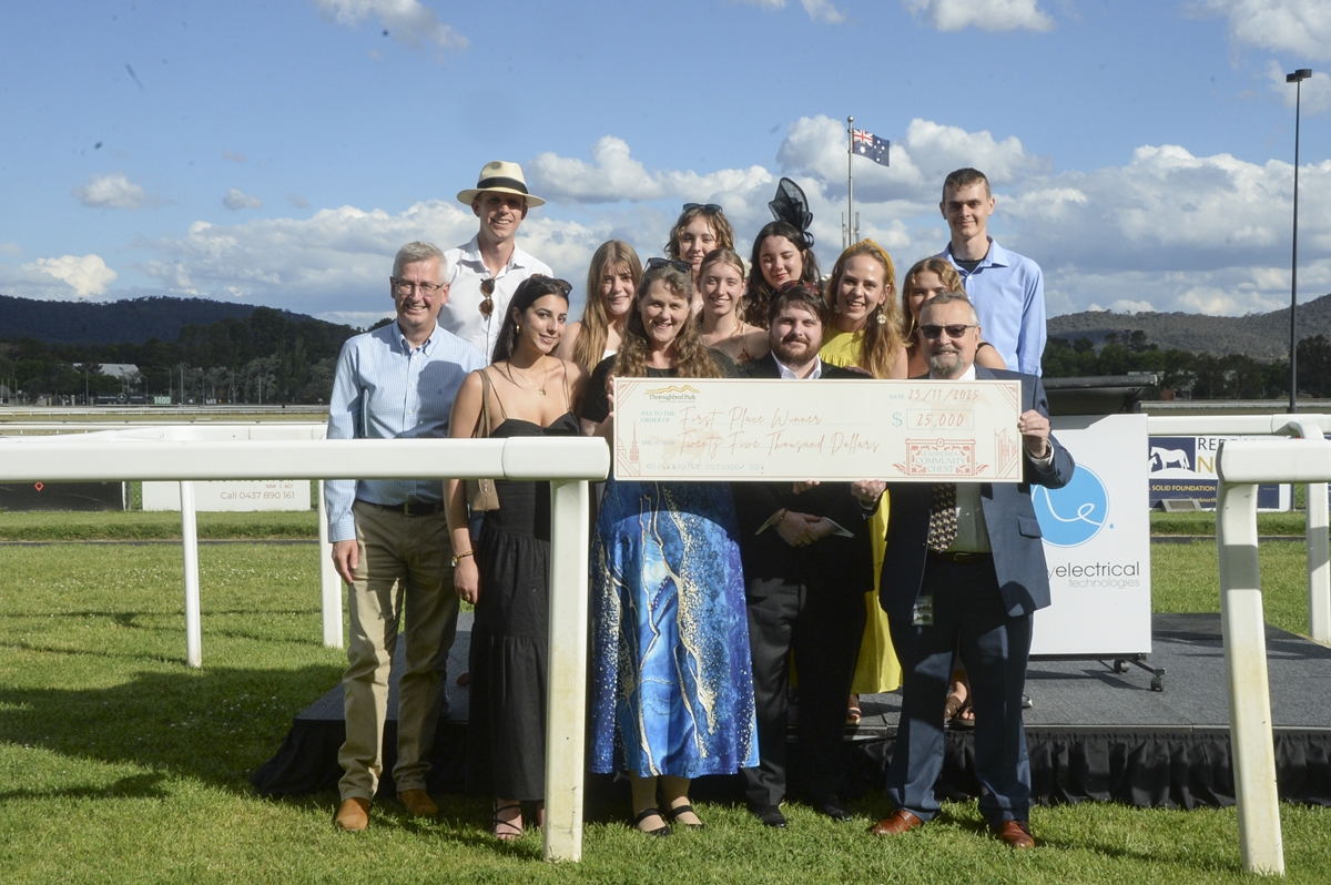 a group of people holding a novelty cheque trackside