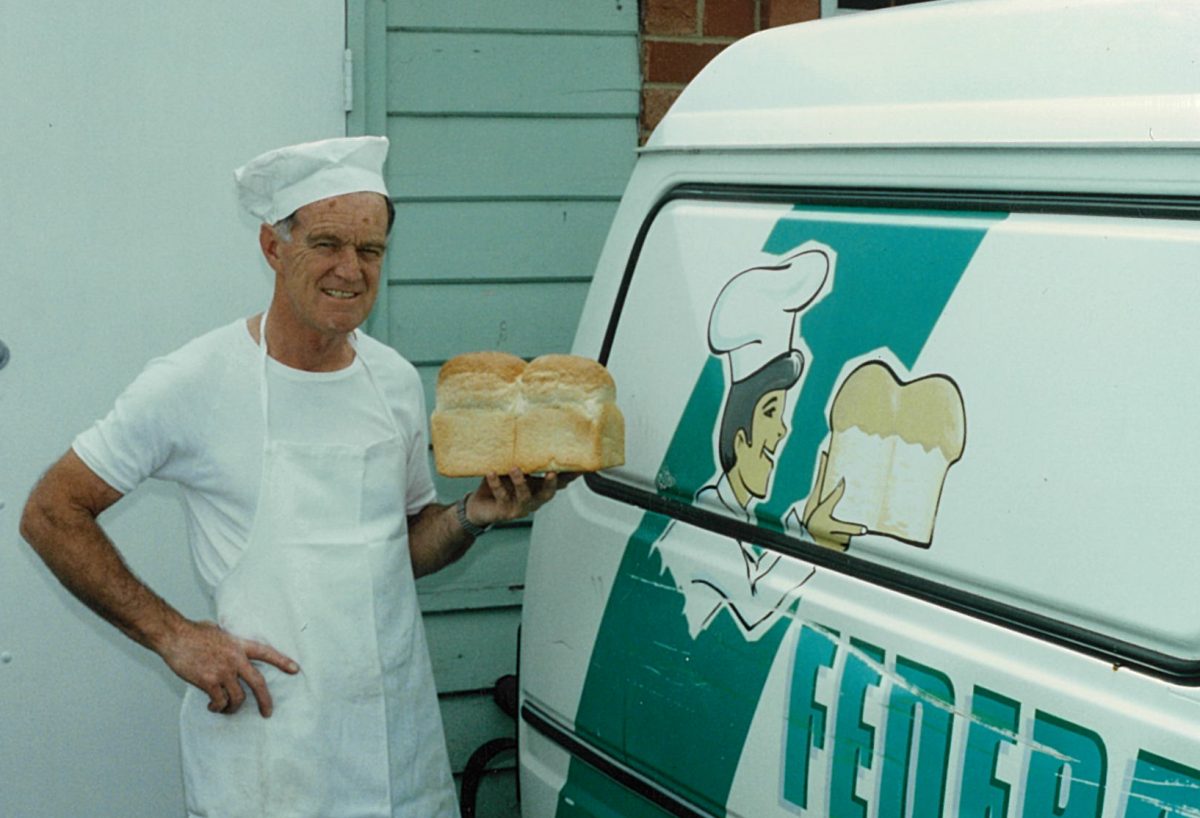 John Coggans standing with a loaf of bread next to the bread truck