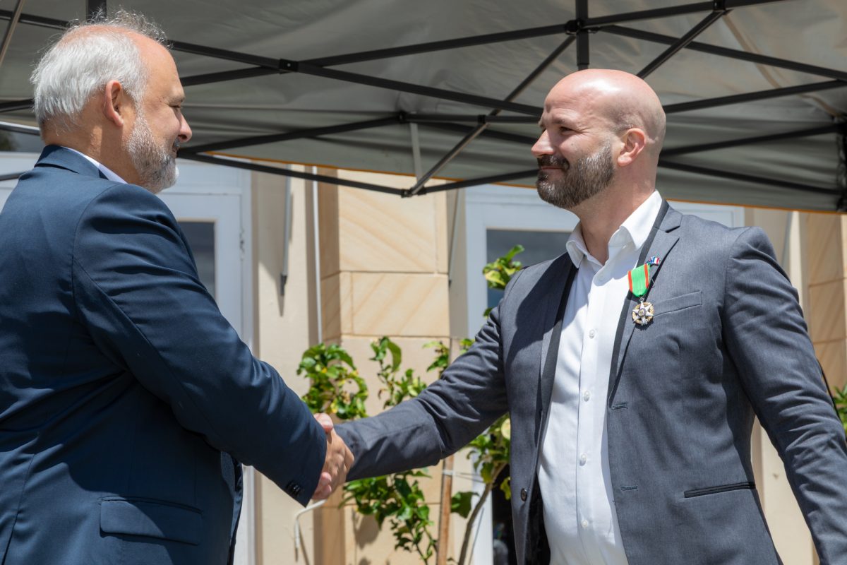 French ambassador Pierre-André Imbert shakes Clement Chauvin's hand after awarding him the French Order of Agricultural Merit