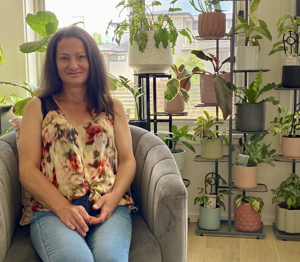 woman sitting in a chair surrounded by plants
