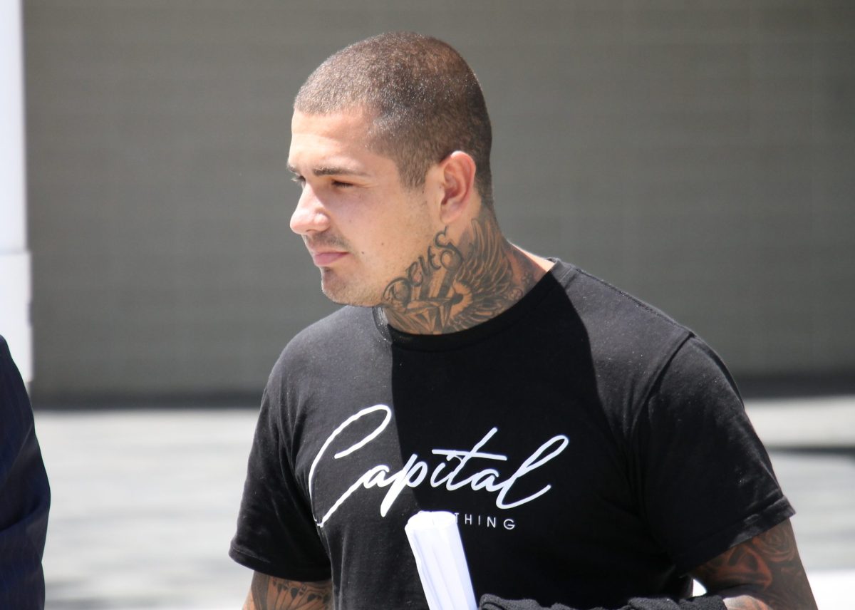tattooed man in a black T-shirt walking outside 