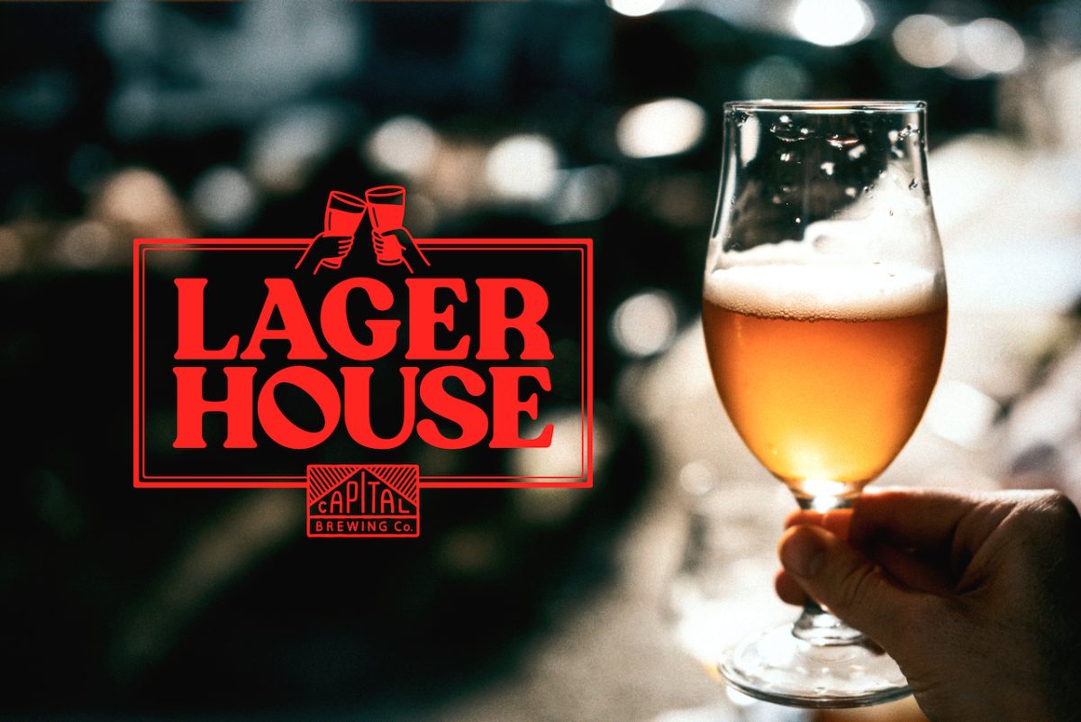 Red text reading "Lager House" with the image of two beers 'cheersing' on top and the Capital brewing logo beneath. The text and logos is super imposed onto a photo of a beer in a curvy, stemmed beer glass.