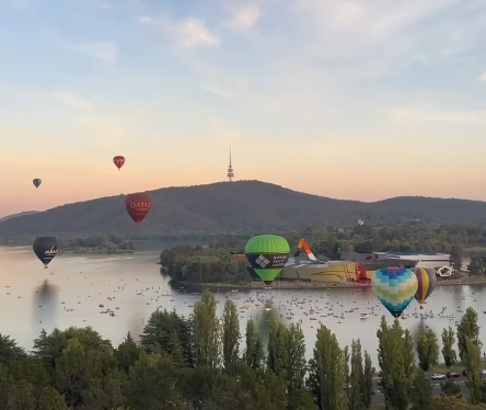hot-air balloons over a lake