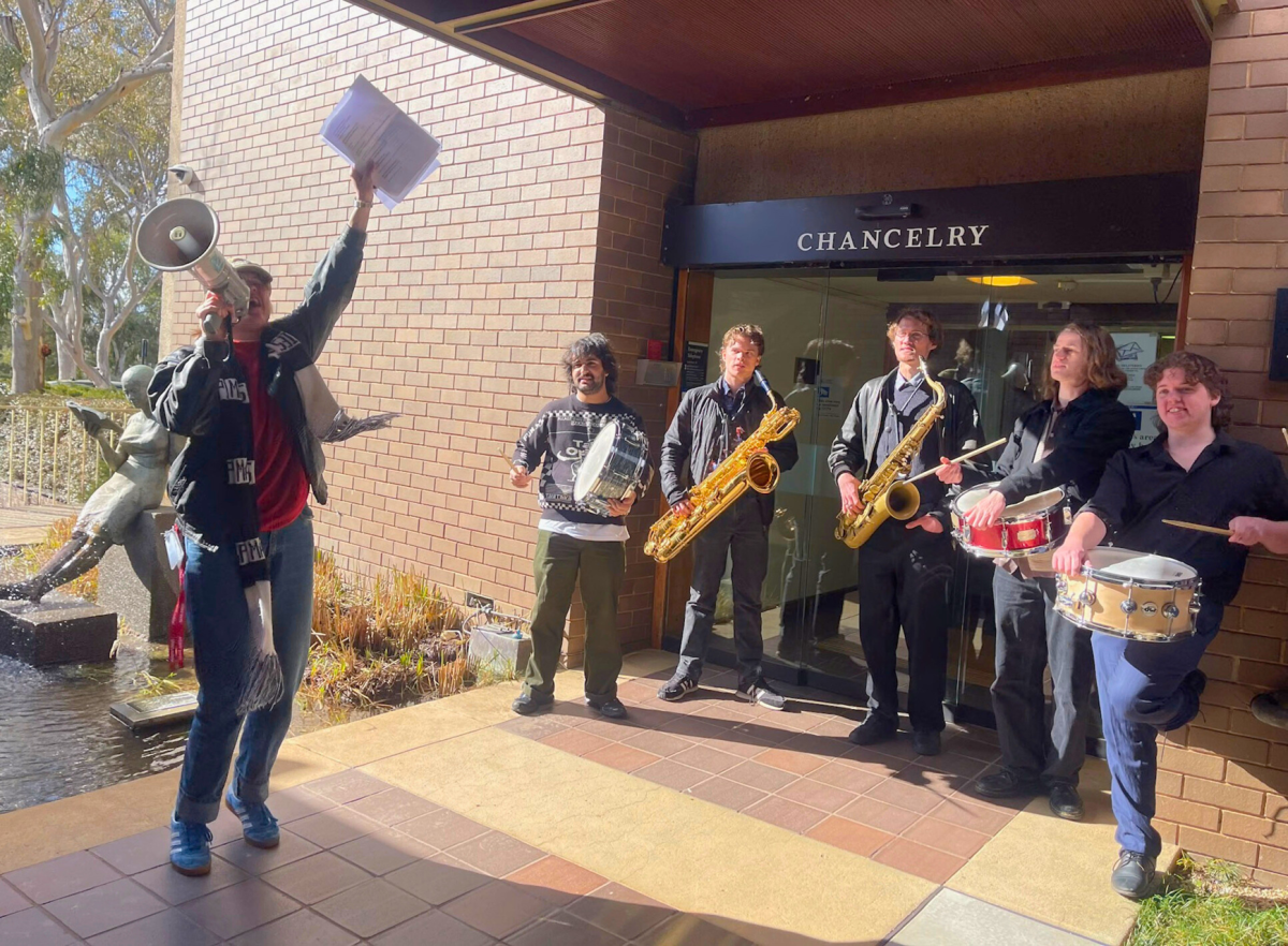 students holding instruments protesting outside the ANU Chancelry