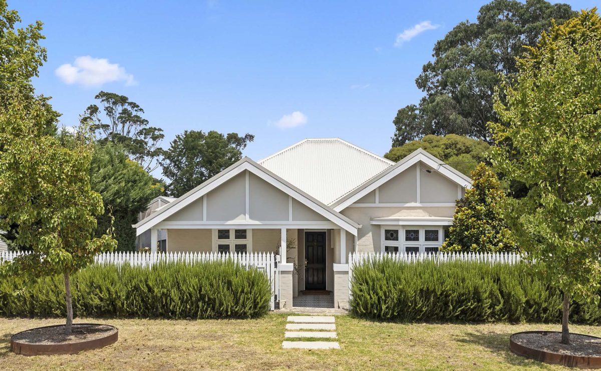 cream-coloured country home with landscaped front lawn