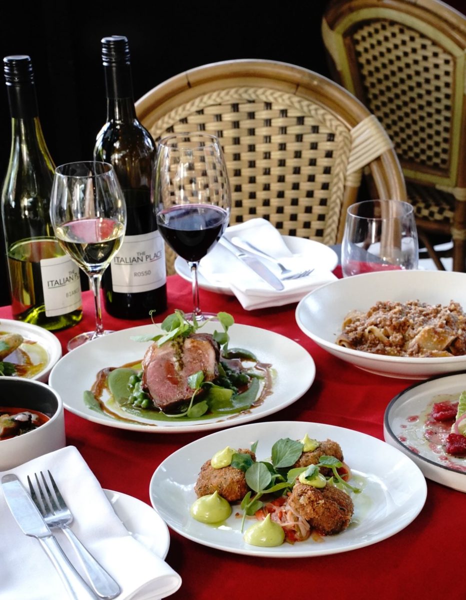 Plates of food and glasses of wine on a table 