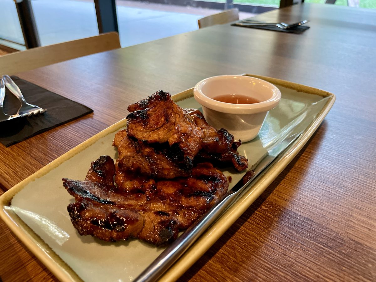 Pieces of charred pork meat on a plate.
