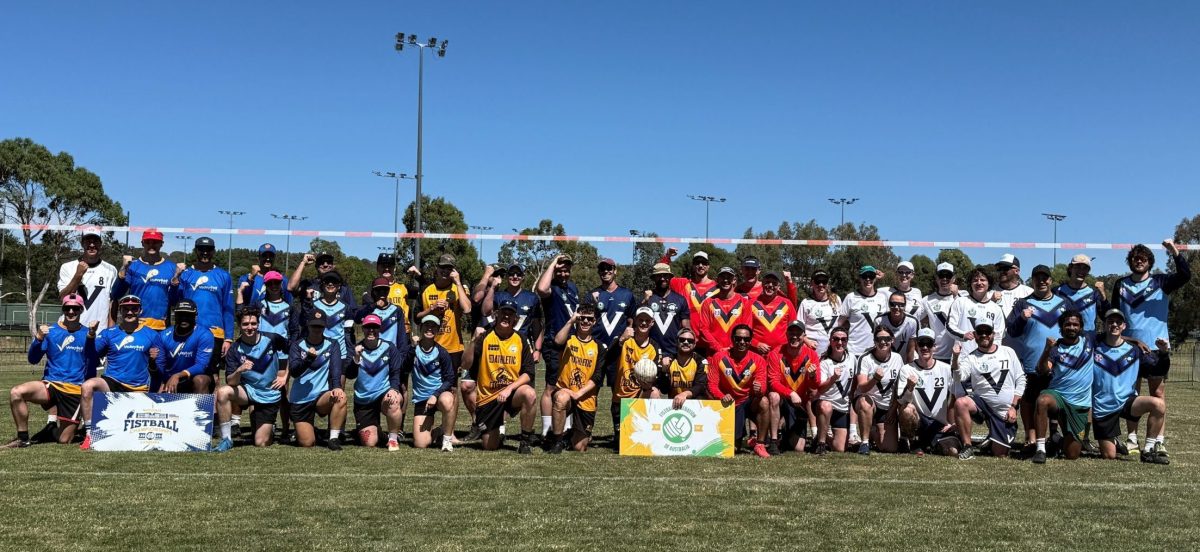 Volleyball teams kneel in the grass