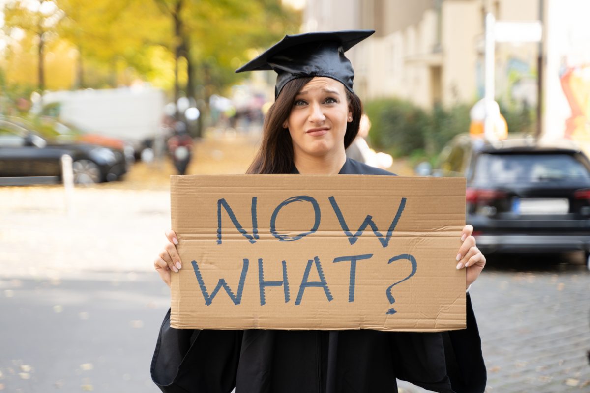 Sad Graduate Student Standing With Now What Placard