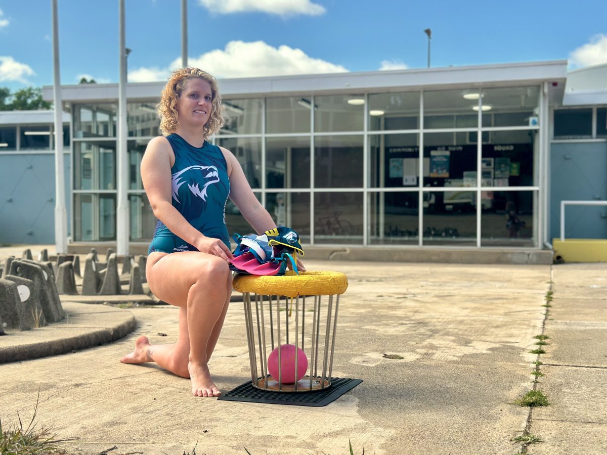 Underwater rugby player posing by equipment