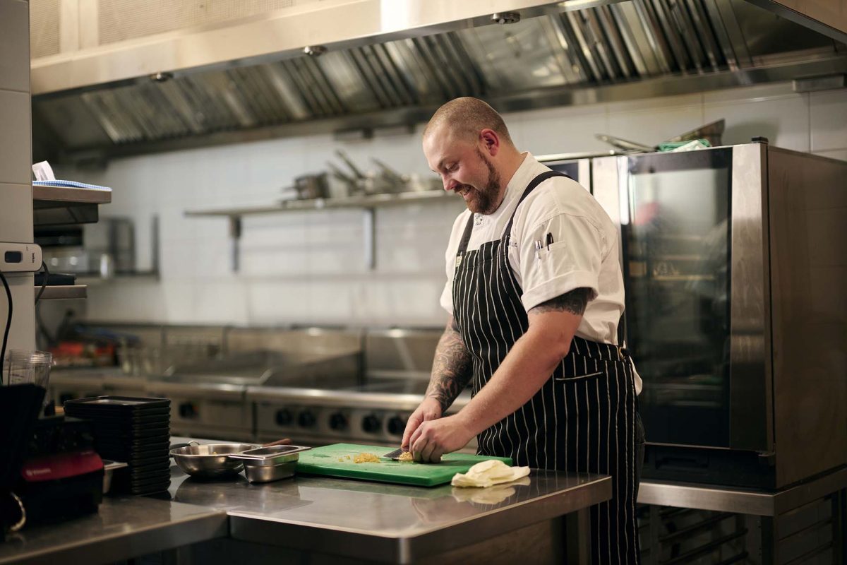 male chef cutting up food