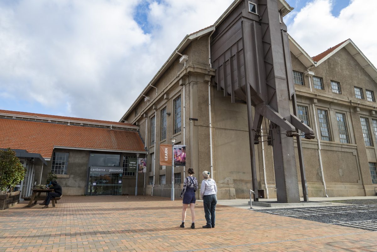 Two people standing outside the Canberra Glassworks building