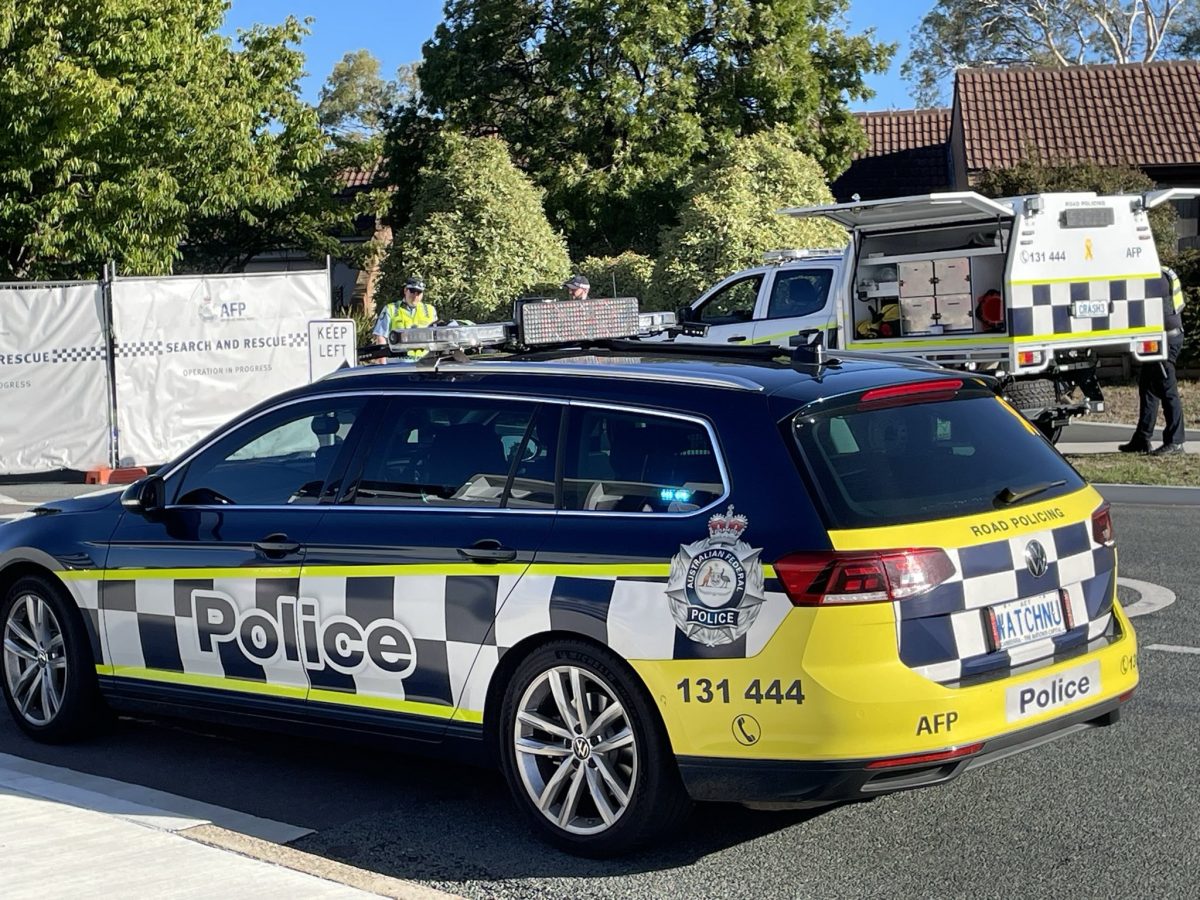 Police cars and a police barrier set up at the scene