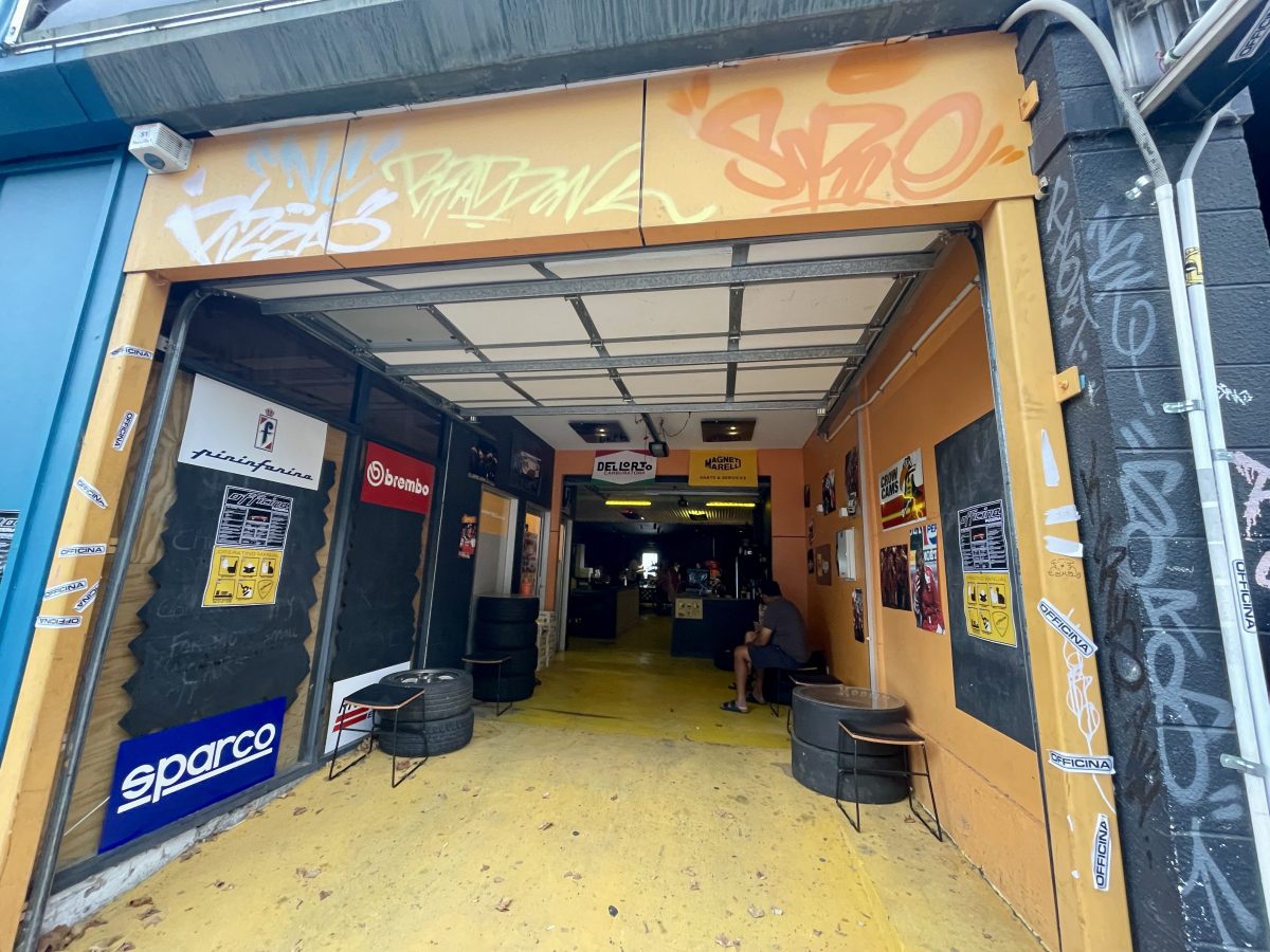 Entrance to the pizza shop with tires, and posters you might expect to find in a mechanics.