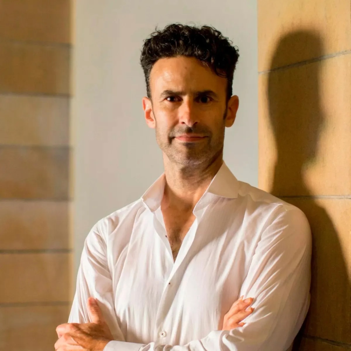 a person wearing a white shirt with arms folded across their chest