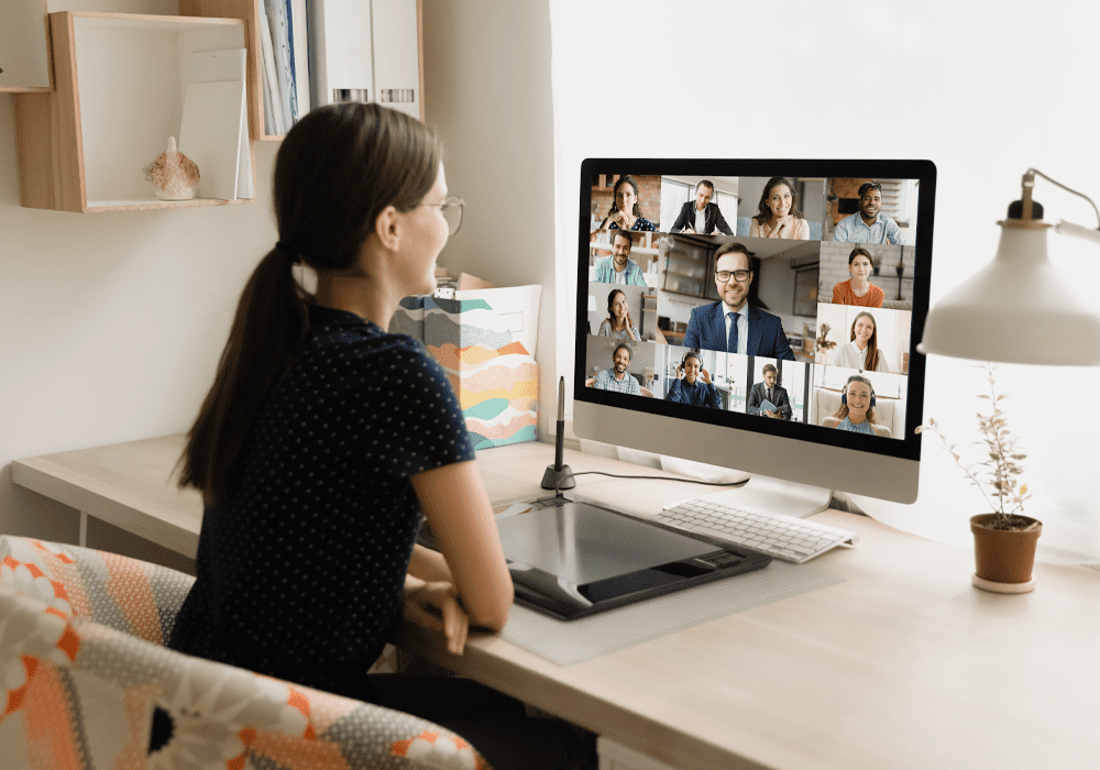 Woman looking at screen with images of colleagues.