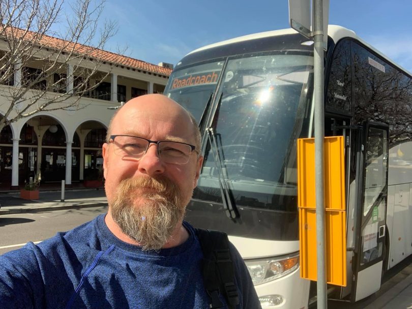 Richard Orchard standing at bus stop in Canberra CBD.