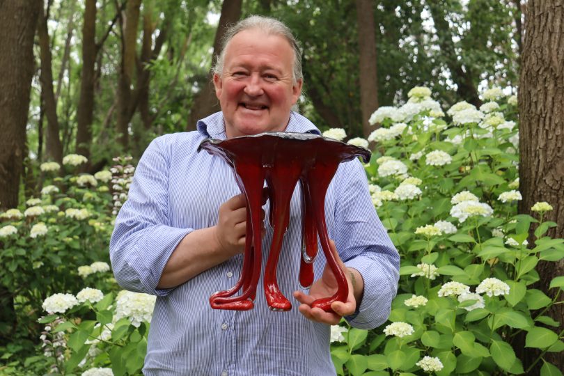 Peter Crisp at Crisp Galleries holding one of his early slump glass pieces.