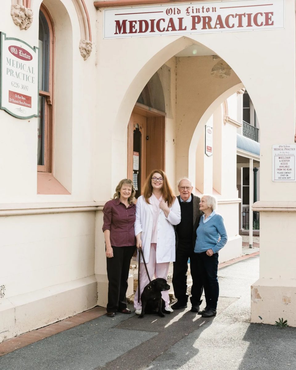Four people and dog outside surgery
