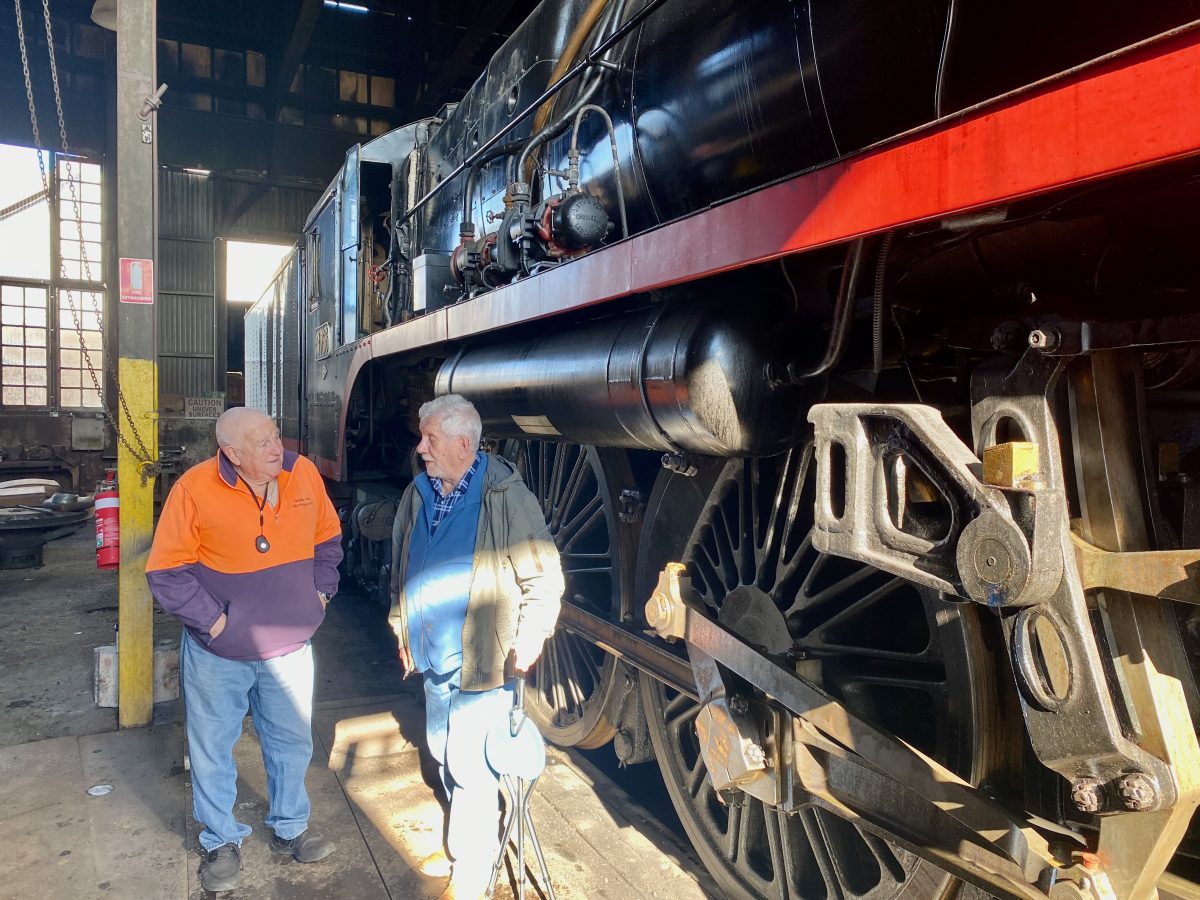Goulburn Loco Roundhouse Preservation Society president Stan O’Donnell and volunteer Dennis Mitchell near Loco 5917 which hauls picnic trains and is maintained at the historic Goulburn depot.