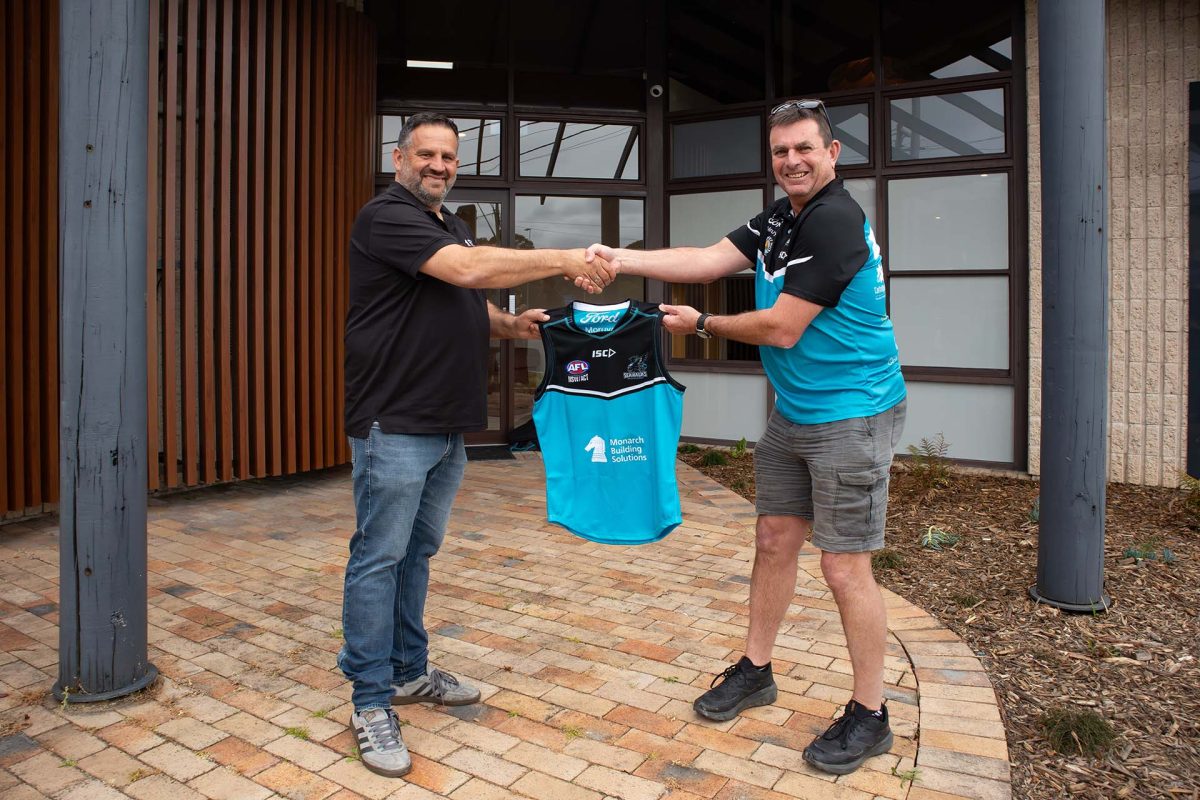 Two people holding a jersey shaking hands