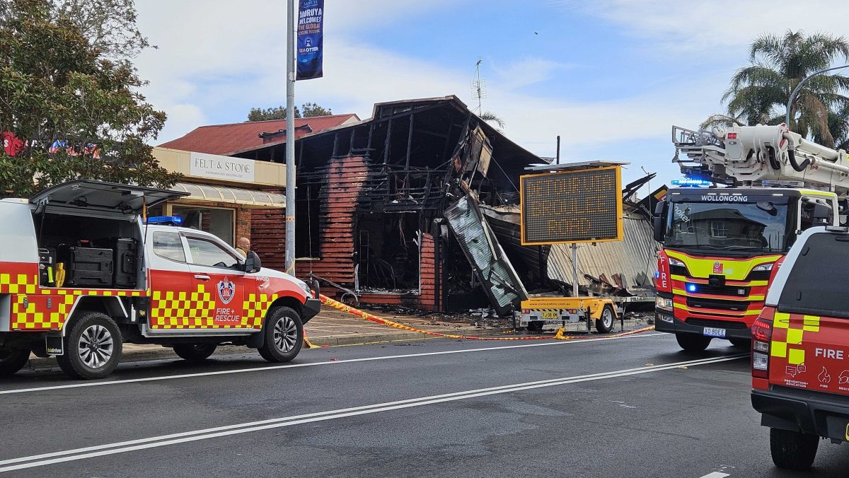 Fire trucks around a burnt building