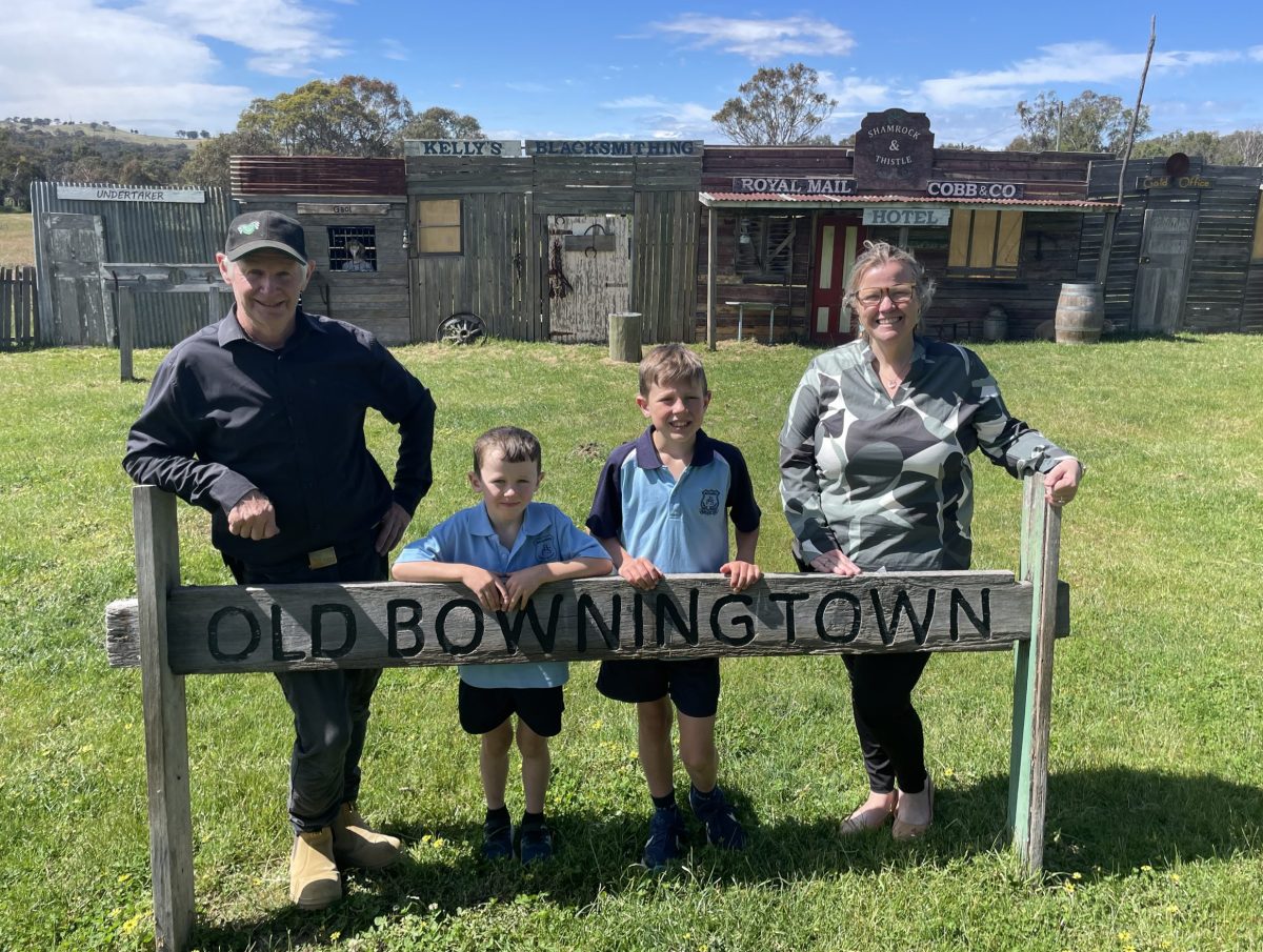 Man, two kids and woman with Old Bywong Town sign.
